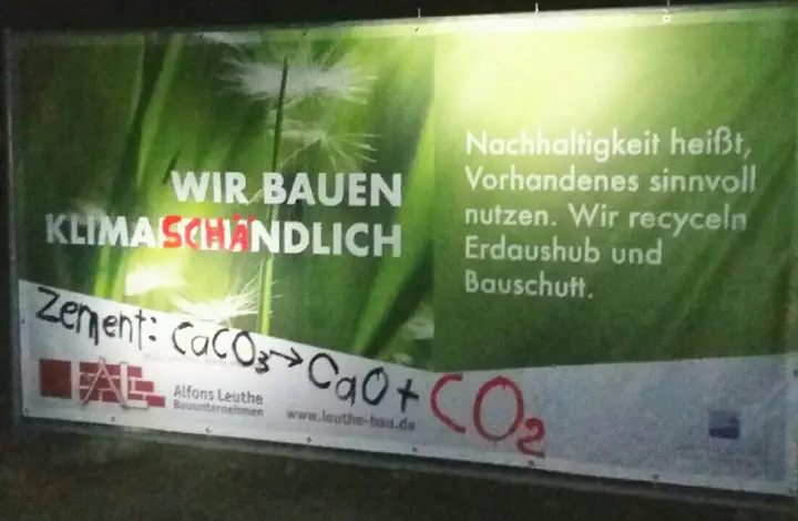 Übermalte Werbung weißt nun darauf hin, dass Zement zwangsweise CO2 freisetzt